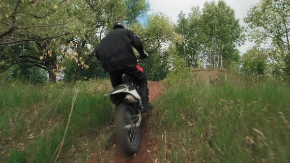 Motorcyclist Racing through Forest