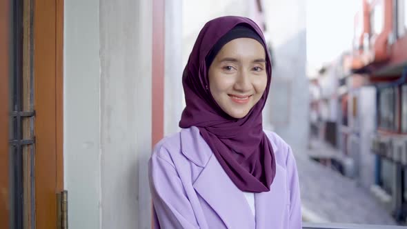 Portrait of beautiful young muslim woman wearing hijab headscarf looking at camera smiling happy 