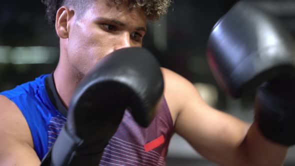 Boxer Practicing Blows with Punching Bag