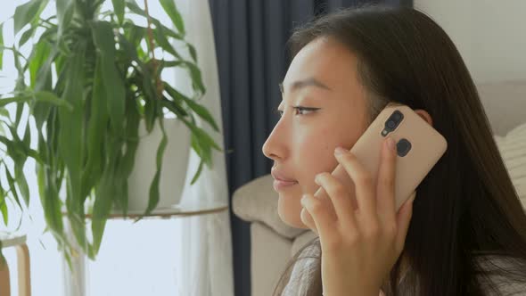 Smiling asian woman talking on phone