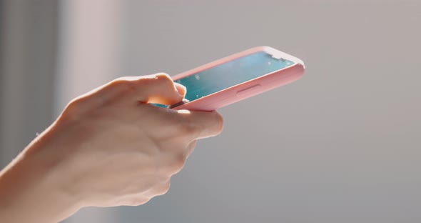 Hand of Girl Using Smartphone at Bedroom at Home Typing Message