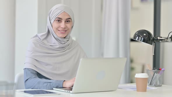 Young Arab Woman with Laptop Smiling at Camera