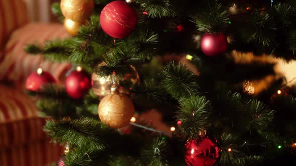 Video of Camera Slowly Moving and Panning Over Colorful Glowing Lights and Baubles on Christmas Tree