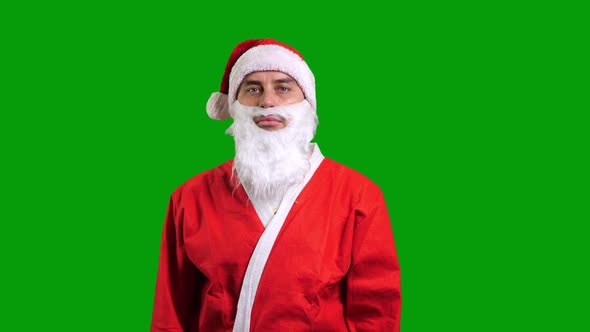 Santa Claus in Red Suit Pointing Aside to the Corner on Green Chroma Key Background