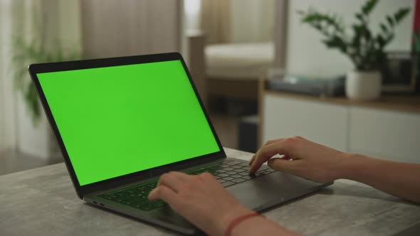 Hands Typing on a Laptop with Chroma Key Green Screen Indoors