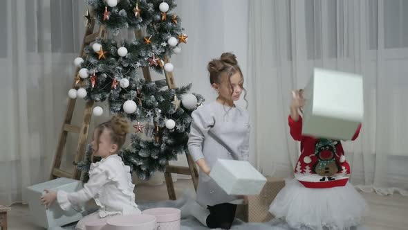 Happy American family celebrating Christmas. Children open a gift at home.