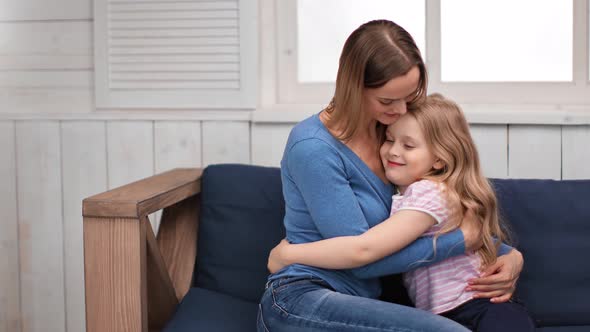 Happy Adorable Young Mother Hugging Little Daughter