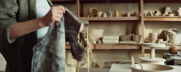 Woman Putting on Apron in Pottery Studio