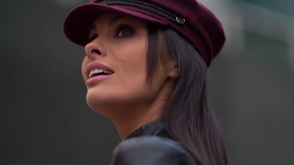 Close-up Portrait of a Beautiful Dark-haired Female Model in a Purple Cap and Leather Jacket Posing