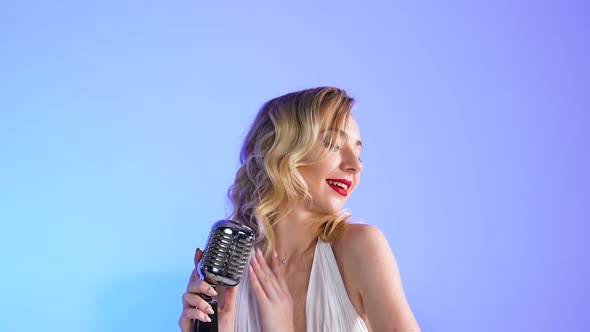 Pretty Young Woman in the Image of Merlin Monroe Posing Near a Retro Microphone