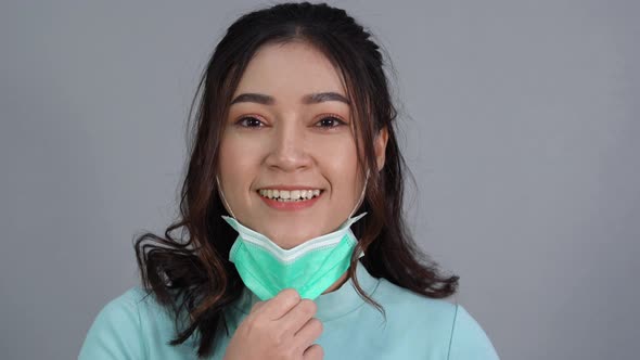 woman removes a medical mask (surgical mask) and smiling