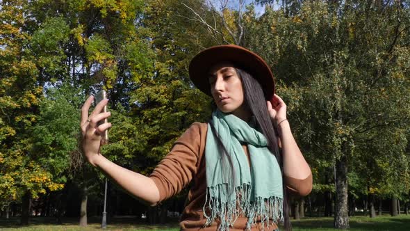 Middle Eastern Woman Taking Selfie in the Park. Mid-autumn, Beautiful Landscape of the Park in the