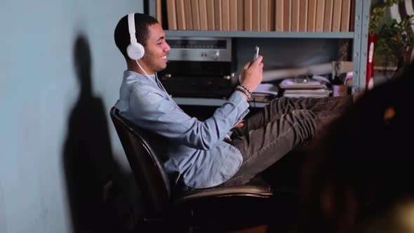 Businessman sitting at the desk listening to music