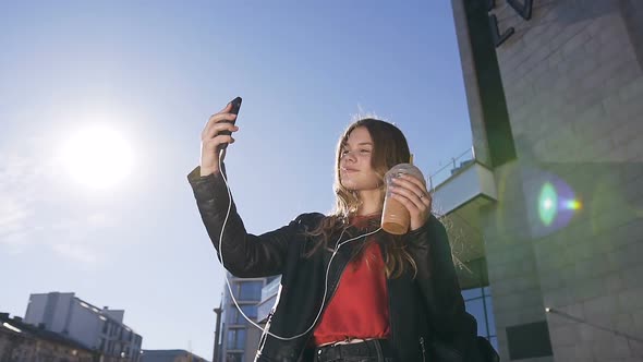 Pretty Young Blonde Girl Taking Selfie Photos on the Smartphone Device Camera