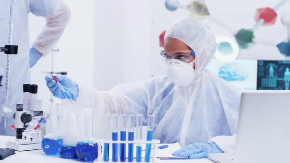 Chemist in a Modern Science Laboratory Using Blue Liquid for Test