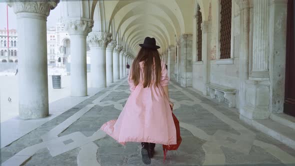 Woman Walks in Building with Columns at St