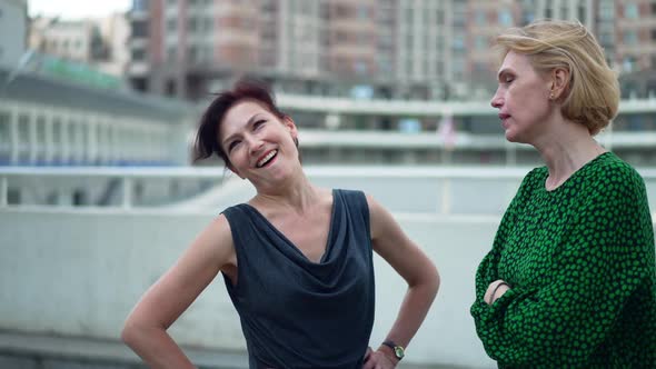 Two Angry Women Arguing in Slow Motion Standing on Urban City Street Outdoors