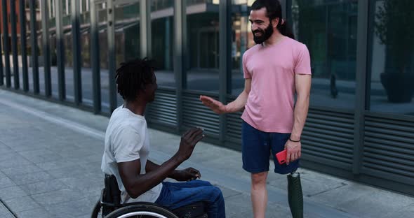 Multiethnic friends with disability greeting each other in the city