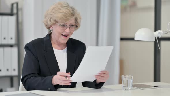 Old Businesswoman Excited By Success on Documents