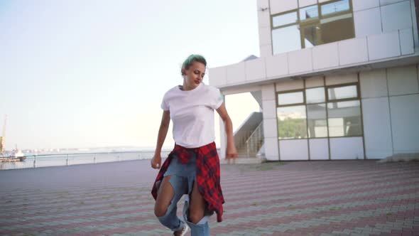 Attractive Young Woman in a Stylish Look and Green Hair Dancing Freely on Urban Background Slow