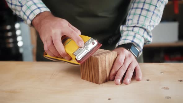 Close Up of Craftsman Hands Sanding the Surface of Handmade Wooden Box with Abrasive Paper, Man