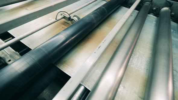 Metal Sheet Moving Through Rollers at Metal Working Factory