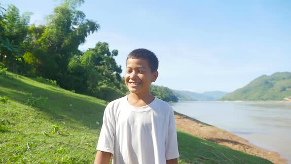 Boy Walking And Smiling Near The River