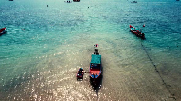 A drone shot of a long tail boat moored near koh tao beach