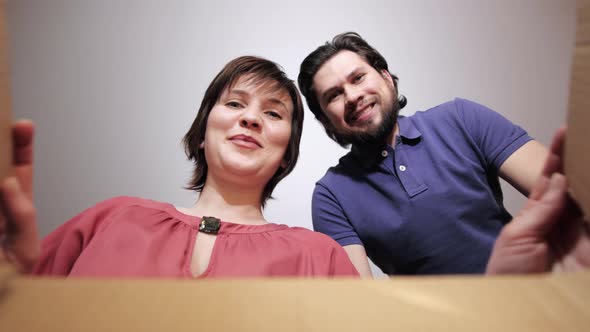 Happy Couple Unpacking Cardboard Box Parcel