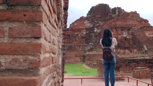 Asian woman using camera for take a picture while spending holiday trip at Ayutthaya, Thailand.