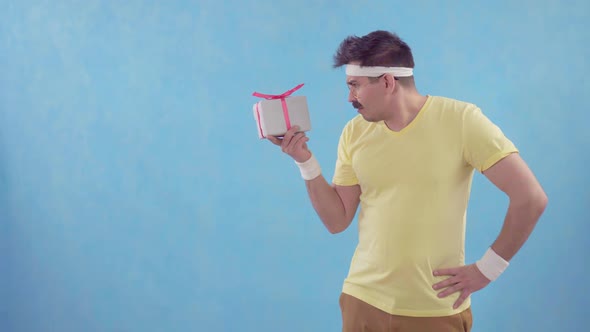 Frustrated Funny Man with Moustache Gets a Big Packed Gift