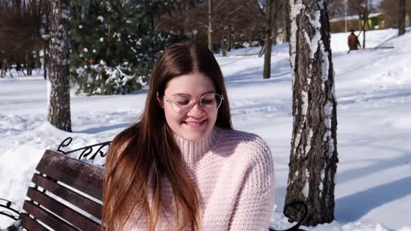 Beautiful Young Woman Wearing Eye Glasses in Knitted Sweater in Winter Park