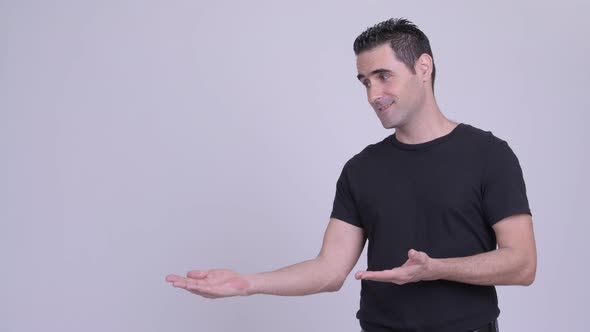 Happy Handsome Man Showing Something Against White Background