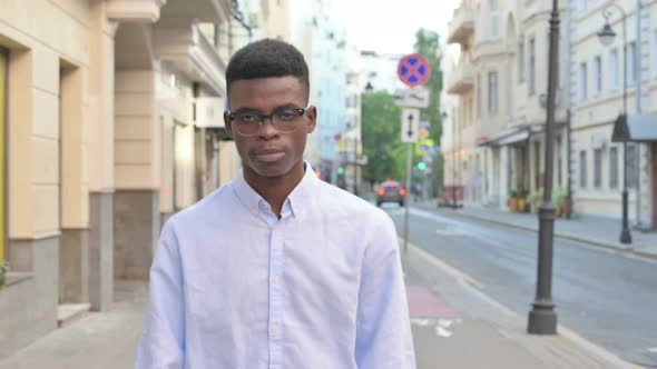 Smiling African Man Walking on the Street Front Pose