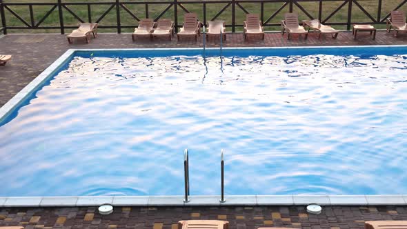 Top View of Swimming Pool with Clear Water on Vacation on Sunset Background