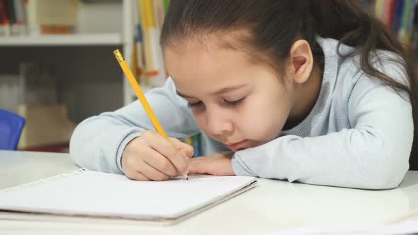 Adorable Little Girl Drawing in Her Notebook