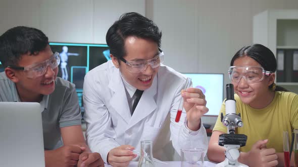 Young Asian Boy And Girl Exciting While Learning Science Experiment With Teacher In Classroom