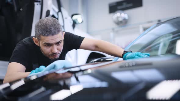 A Man Rubs the Surface of the Car After Polishing