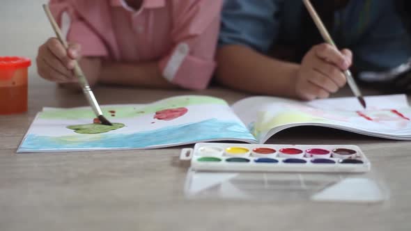 A Little Boy and a Little Girl Paint with Paint on the Album Lying on the Floor