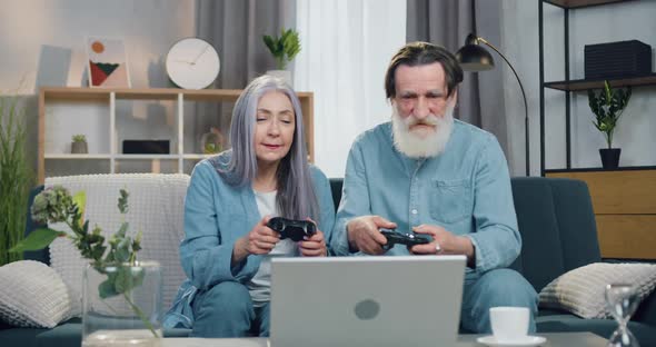 Old Couple Enjoying their Victory in Video Game and Giving High Five Each