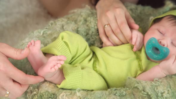 Mothers Hands Holding Legs of Newborn Baby Girl