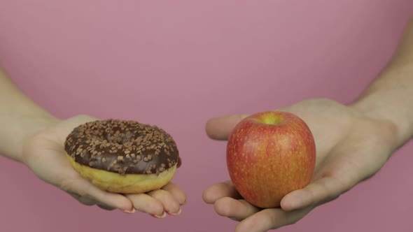Hands Holds Donut and Apple. Choice Donut Against Apple. Healthy or Junk Food