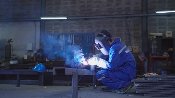 asian male technician worker wear protective uniform welding metal frame wear welders leathers