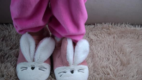 Young Woman Gets Out of Bed and Puts on Pink Slippers in the Morning