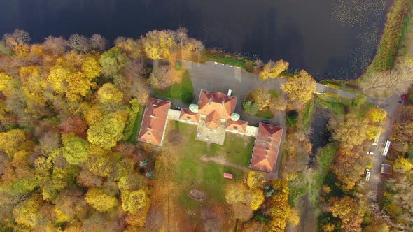 Scenic aerial flight over mist above forrest lake at sunrise, 4K footage. Colorful autumn trees at e