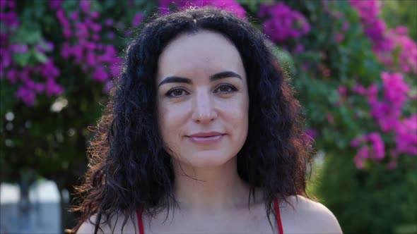 Portrait of a European Young Brunette Girl Looking at the Camera on a Background of Street