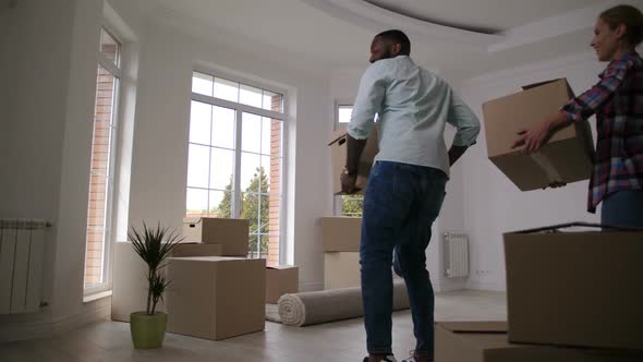 Joyful Family Dancing Carrying Boxes To New House