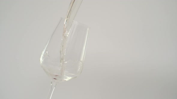 Slow Motion of White Wine Splashing in Glass