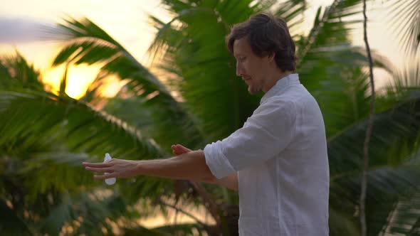 Superslowmotion Shot of a Young Man Applying an Antimosquito Repellent Spray on His Skin