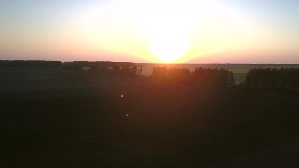 Aerial Motion Above Dark Fields Against Pictorial Sunset